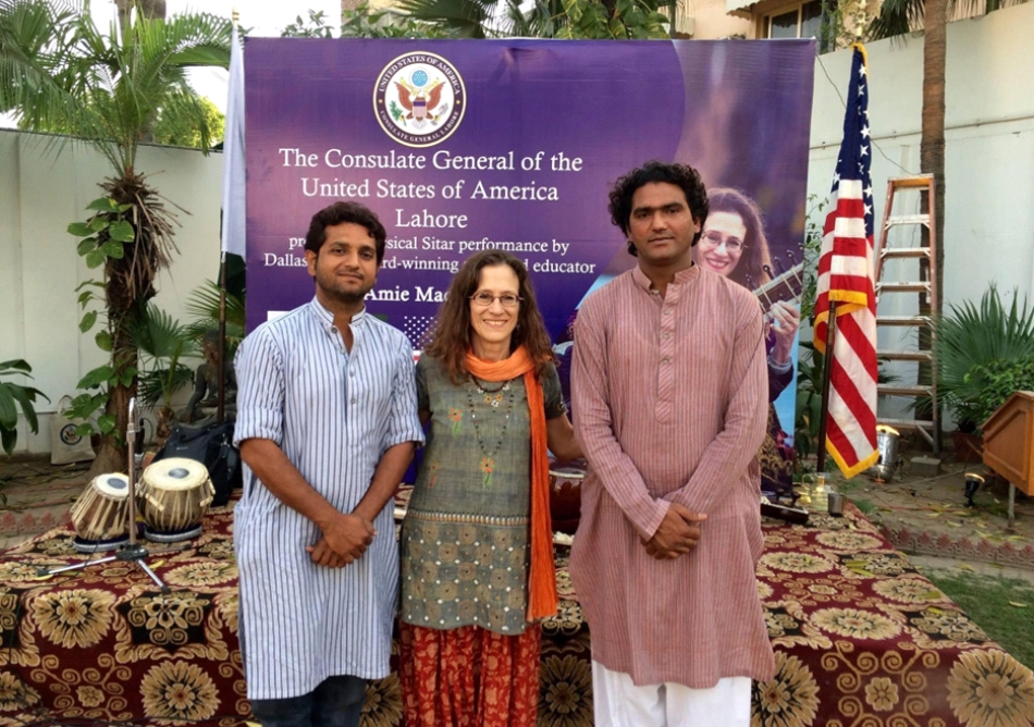 Amie with accompanists Nadeem Haider (L, tanpura) and Riyaaz Ahmed (R, tabla) in front of the stage at the residence of the U.S. Consulate General in Lahore following sound check for their performance. Behind the stage is the official poster bearing the U.S. seal, announcing the performance. Both photos were taken March 2016